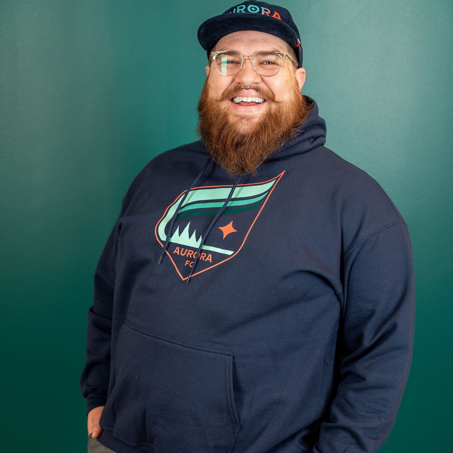 Navy blue hoodie with the Aurora crest that features the colors teal and orange