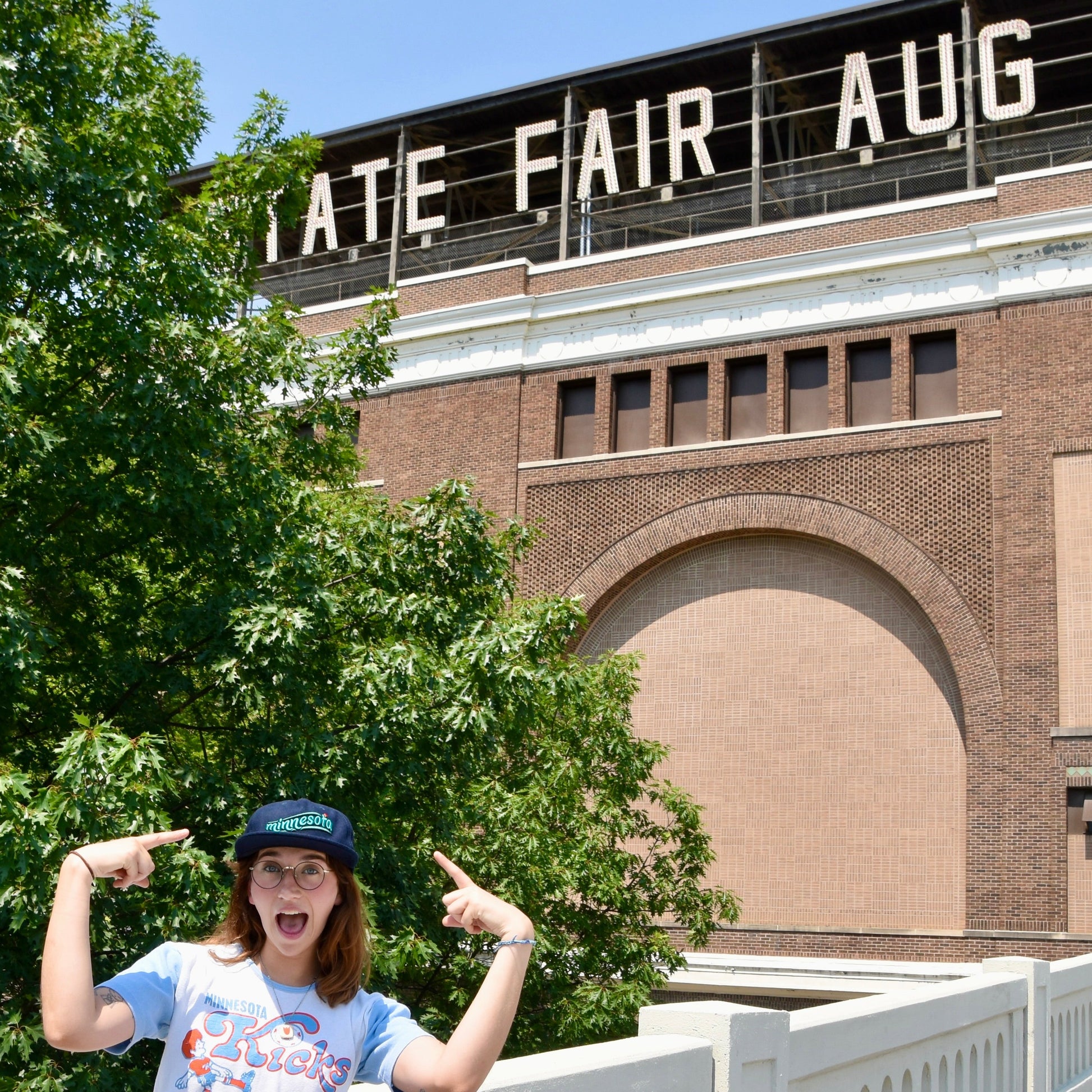 Person wearing a navy minnesota hat outside the MN state fair