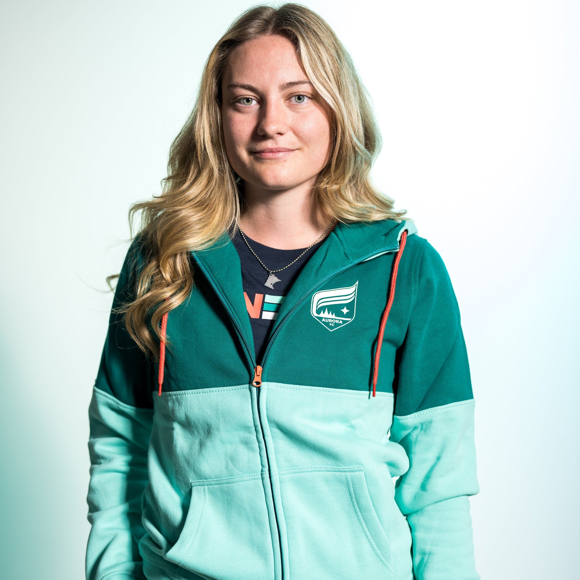 Teal full-zip with the top half in dark teal and the bottom half in light teal with the Aurora crest and orange drawstrings