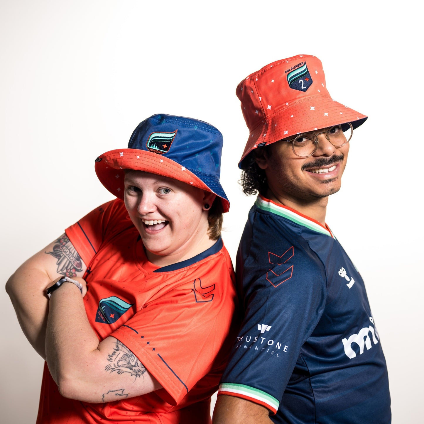 Reversible bucket hat with one side in orange repping the Aurora 2 crest and the other side in blue repping the Aurora crest