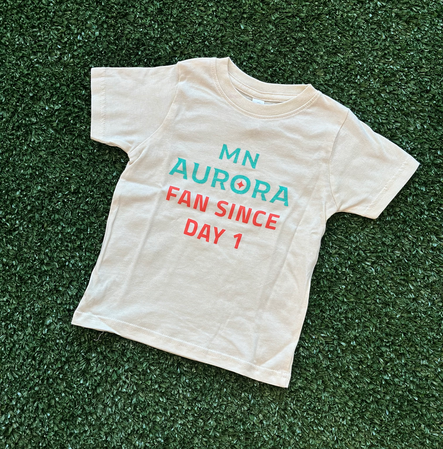 White short-sleeved shirt with the words "MN Aurora Fan Since Day 1" in teal and orange