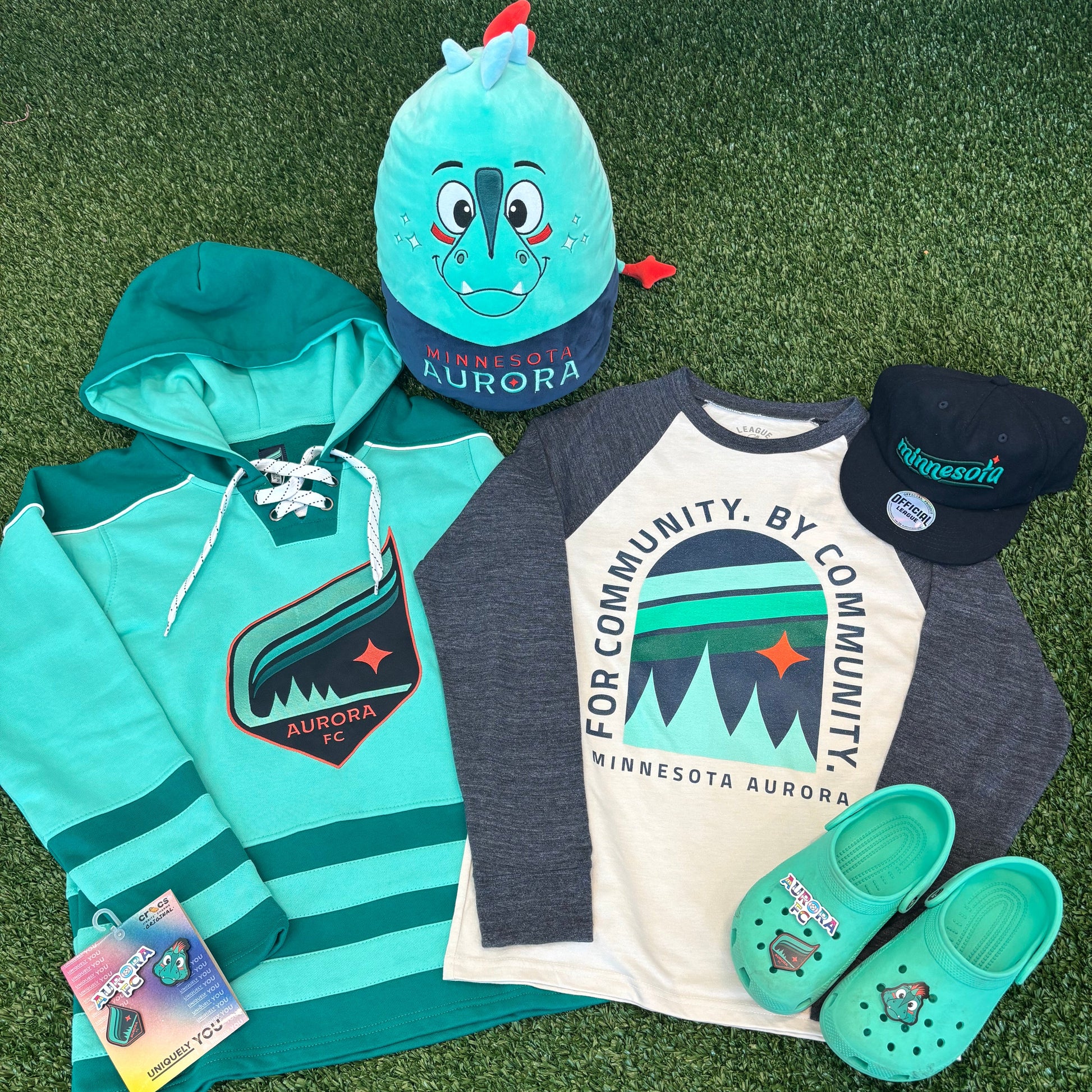 Collection of Aurora clothing and accessories on a green surface