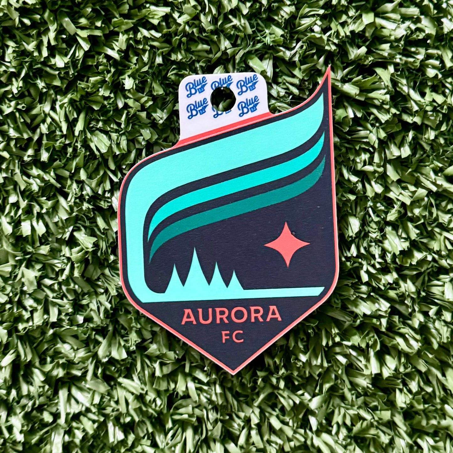 Aurora FC Sticker on a green textured background