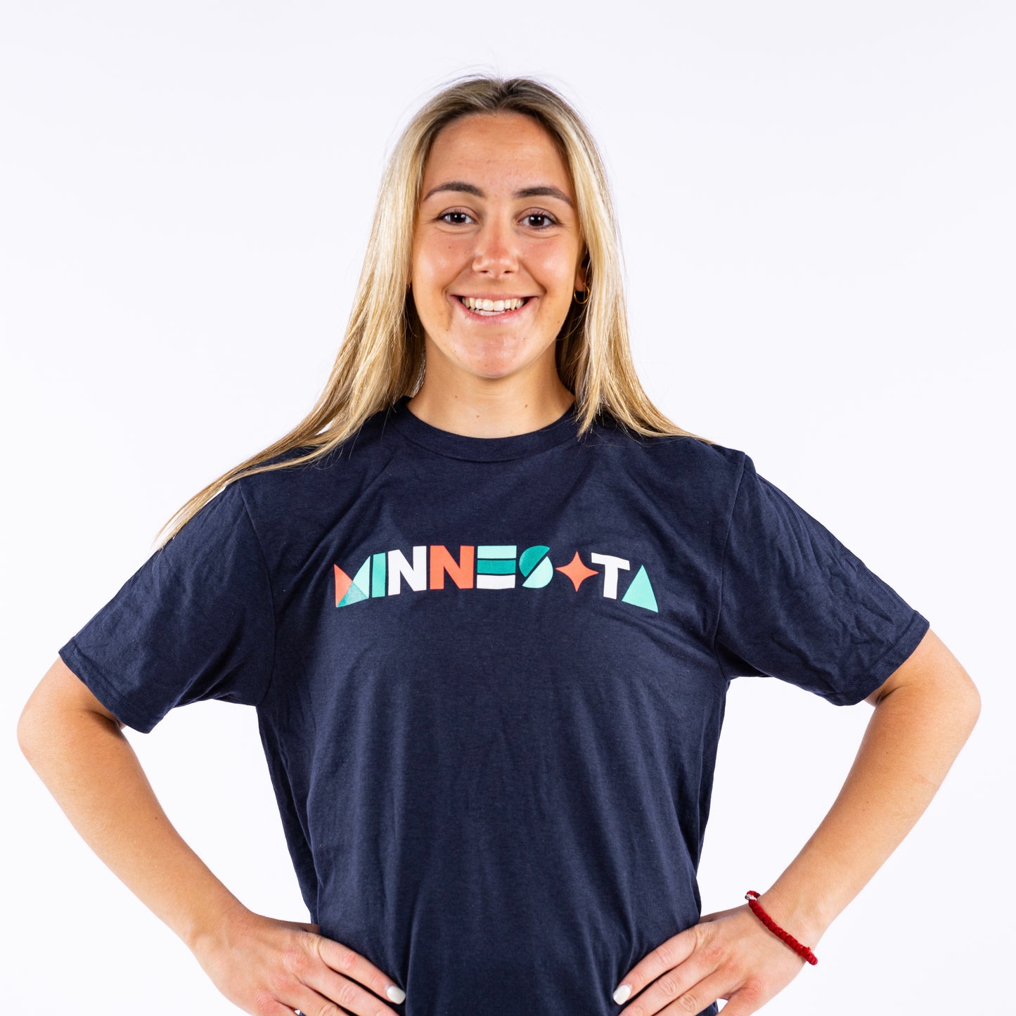 Navy blue short-sleeved shirt with the word "Minnesota" written in different geometric shapes in the colors orange, white, and teal