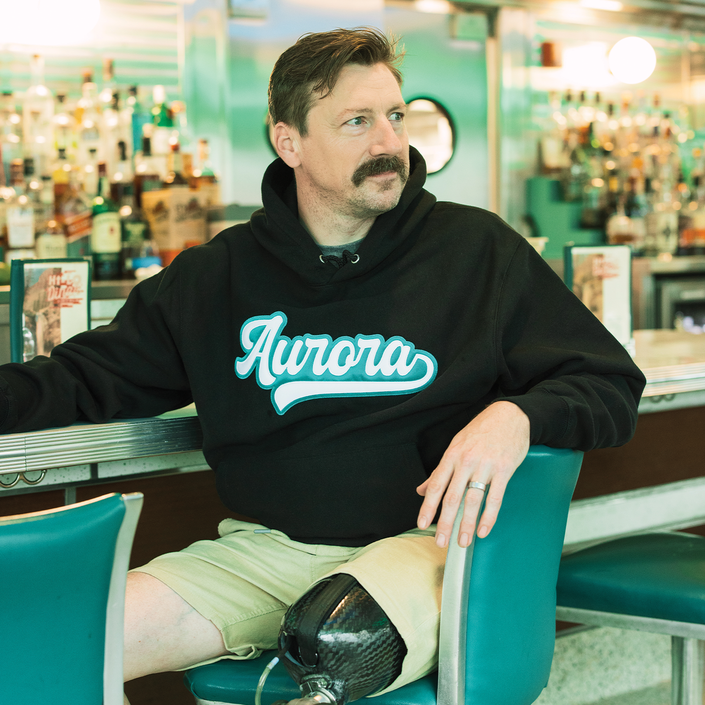 Black hoodie with the word "Aurora" written in white with a teal outline