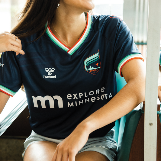 Navy soccer jersey with orange, white, and teal around the collar and the sleeves