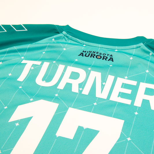 Teal soccer jersey with white stars and lines