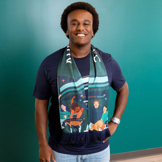 Man wearing a colorful scarf with a teal wall background