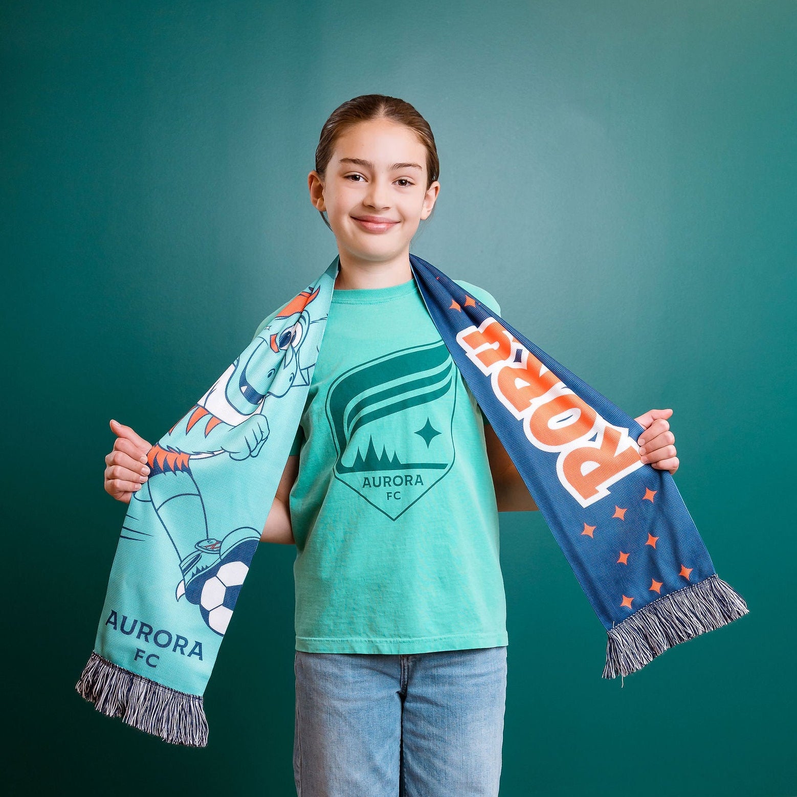 Person holding a scarf with Rory branding against a teal wall.