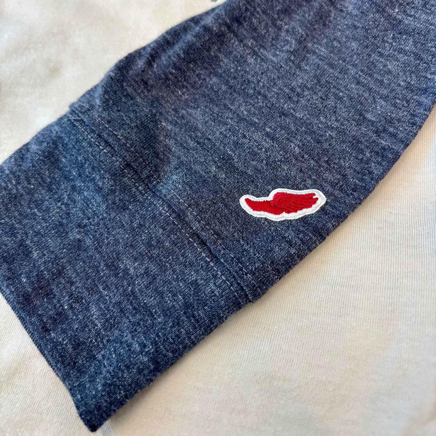 Blue fabric with a red and white logo on a beige surface