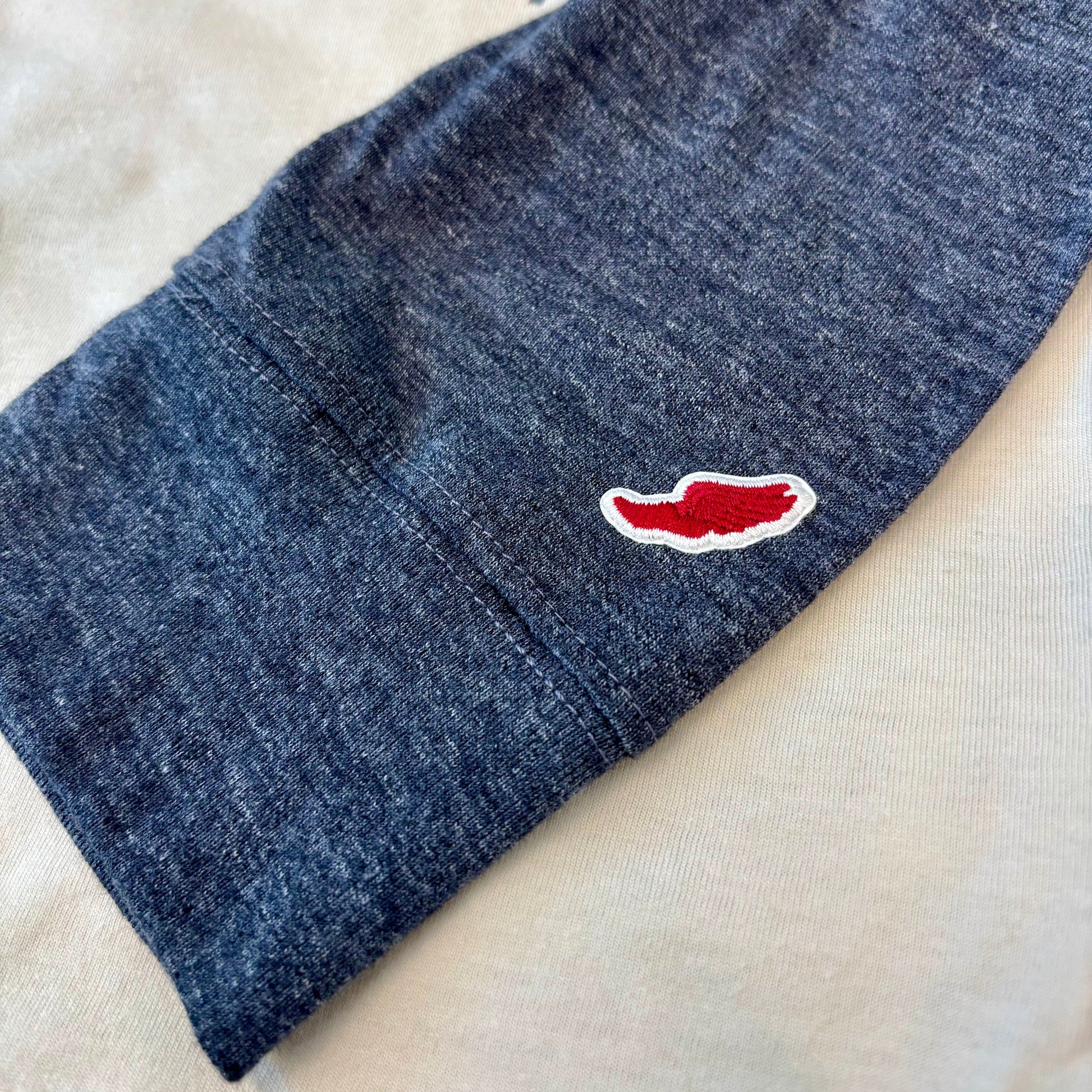 Blue fabric with a red and white logo on a beige surface