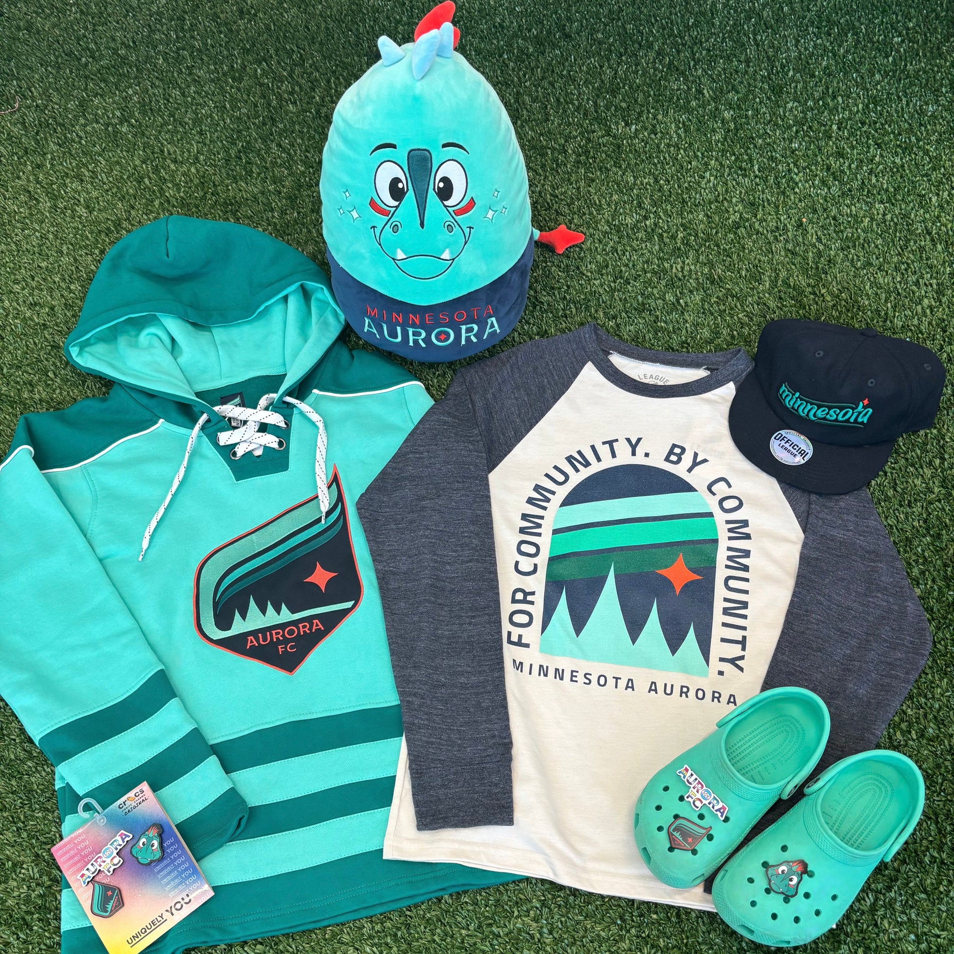 Collection of Aurora clothing and accessories on a green grass background
