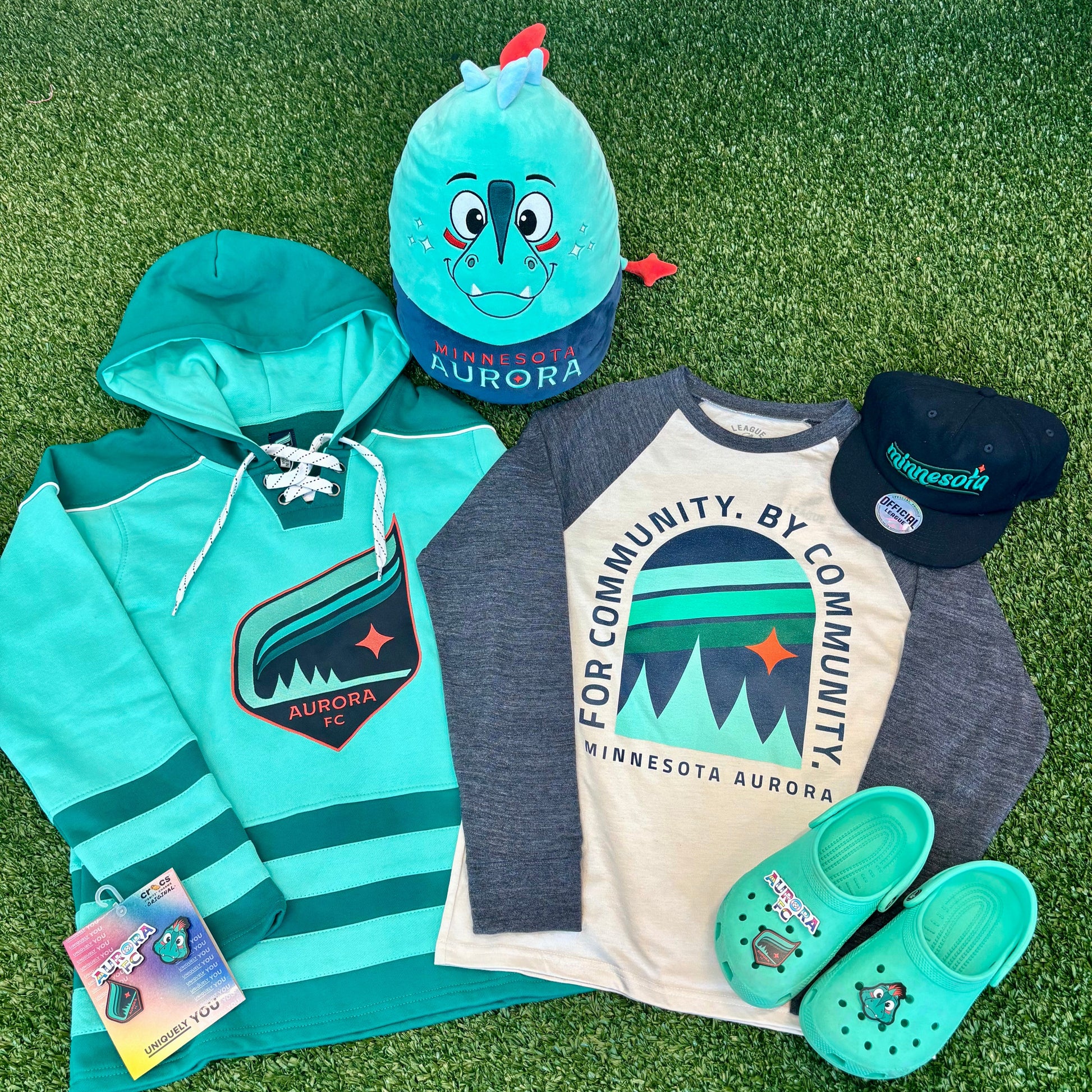 Collection of Aurora clothing and accessories on a grassy background