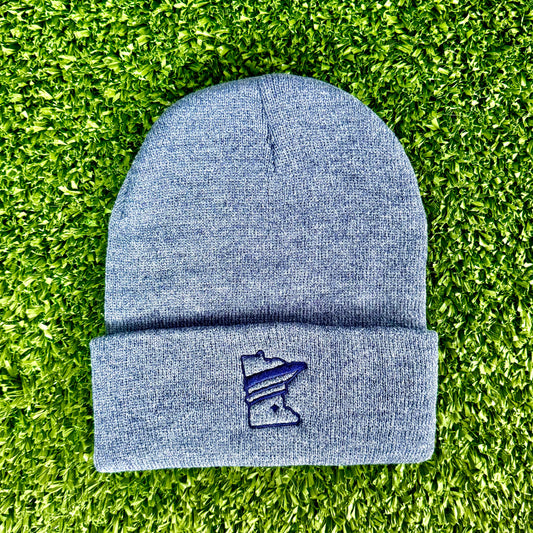 Blue beanie with a logo on a green grass background