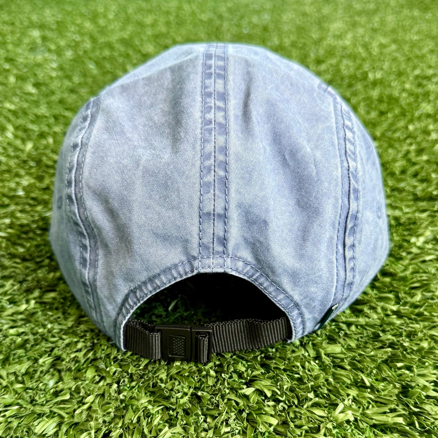 Blue denim cap on green grass
