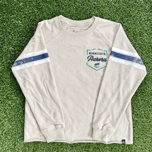 Off white long-sleeve shirt with blue accents on a green grassy surface