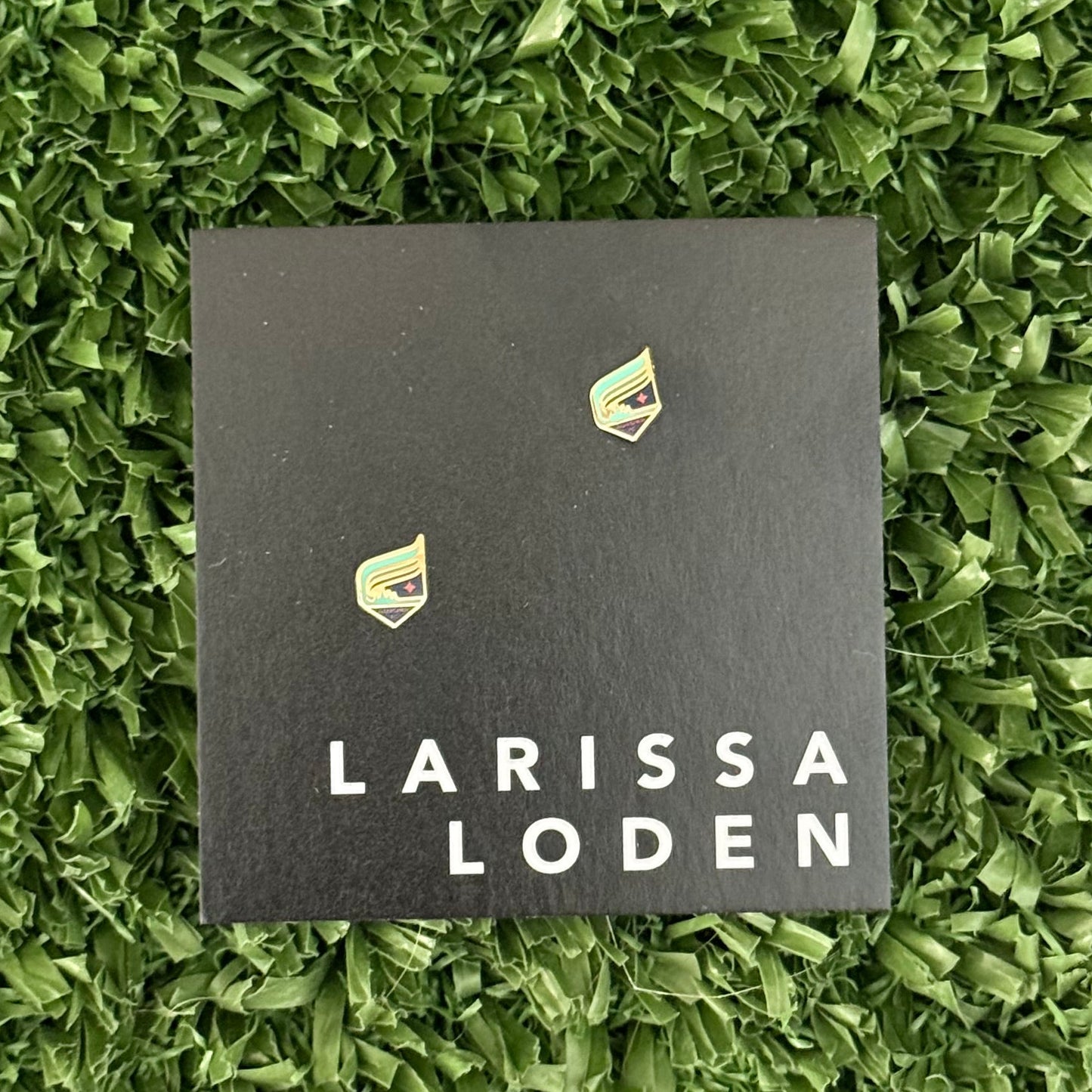 Larissa Loden card with earrings on a green grass background