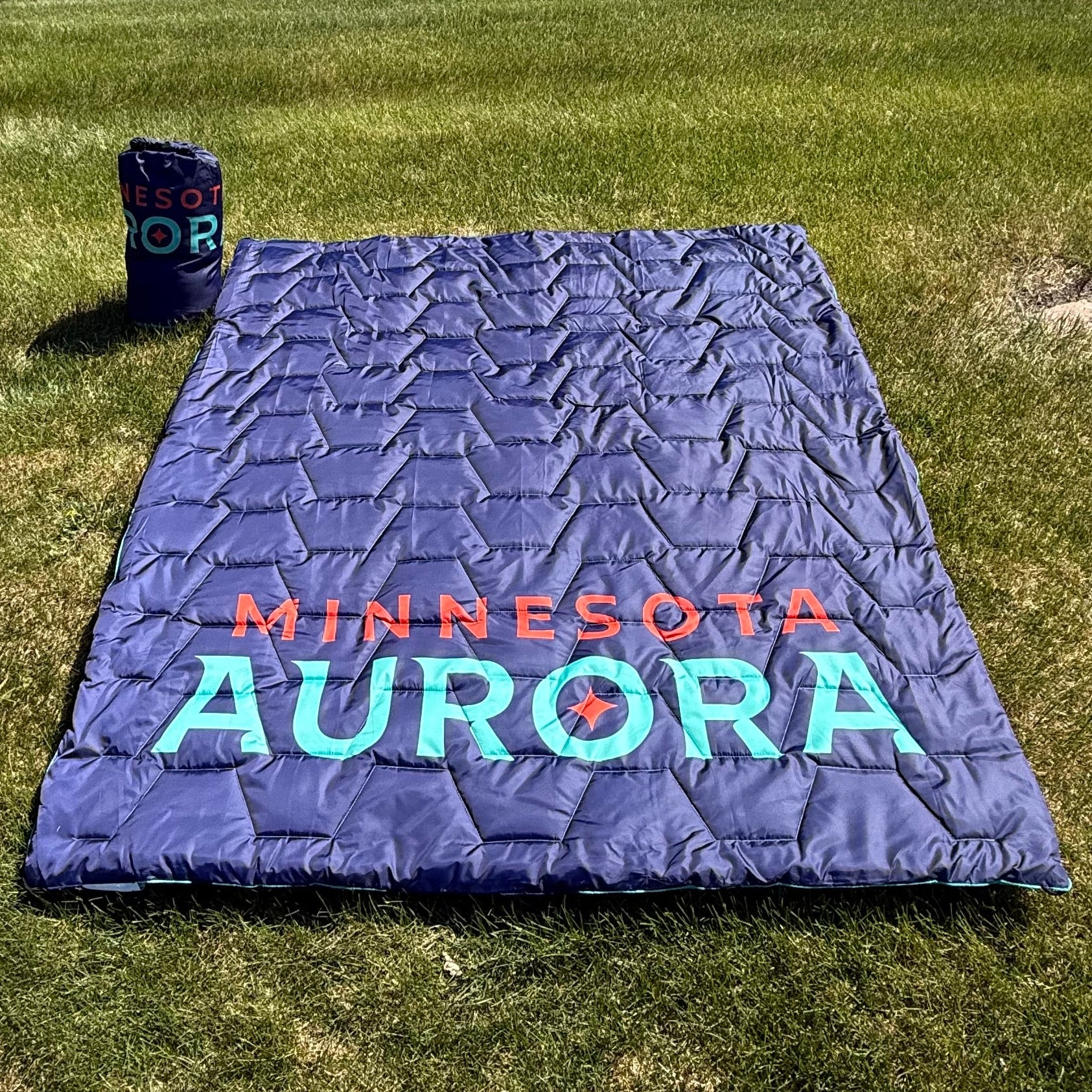 Navy outdoor with 'Minnesota Aurora' text on a grassy area