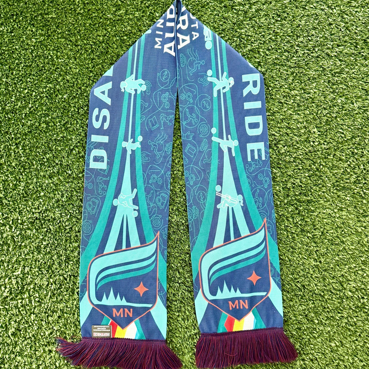 Colorful scarf with disability awareness graphics on a green surface