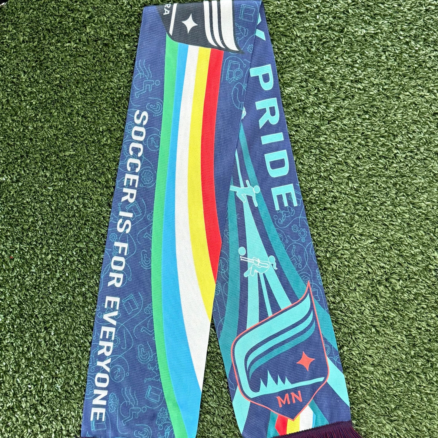 Colorful Disability Awareness scarf  on a green grass-like surface