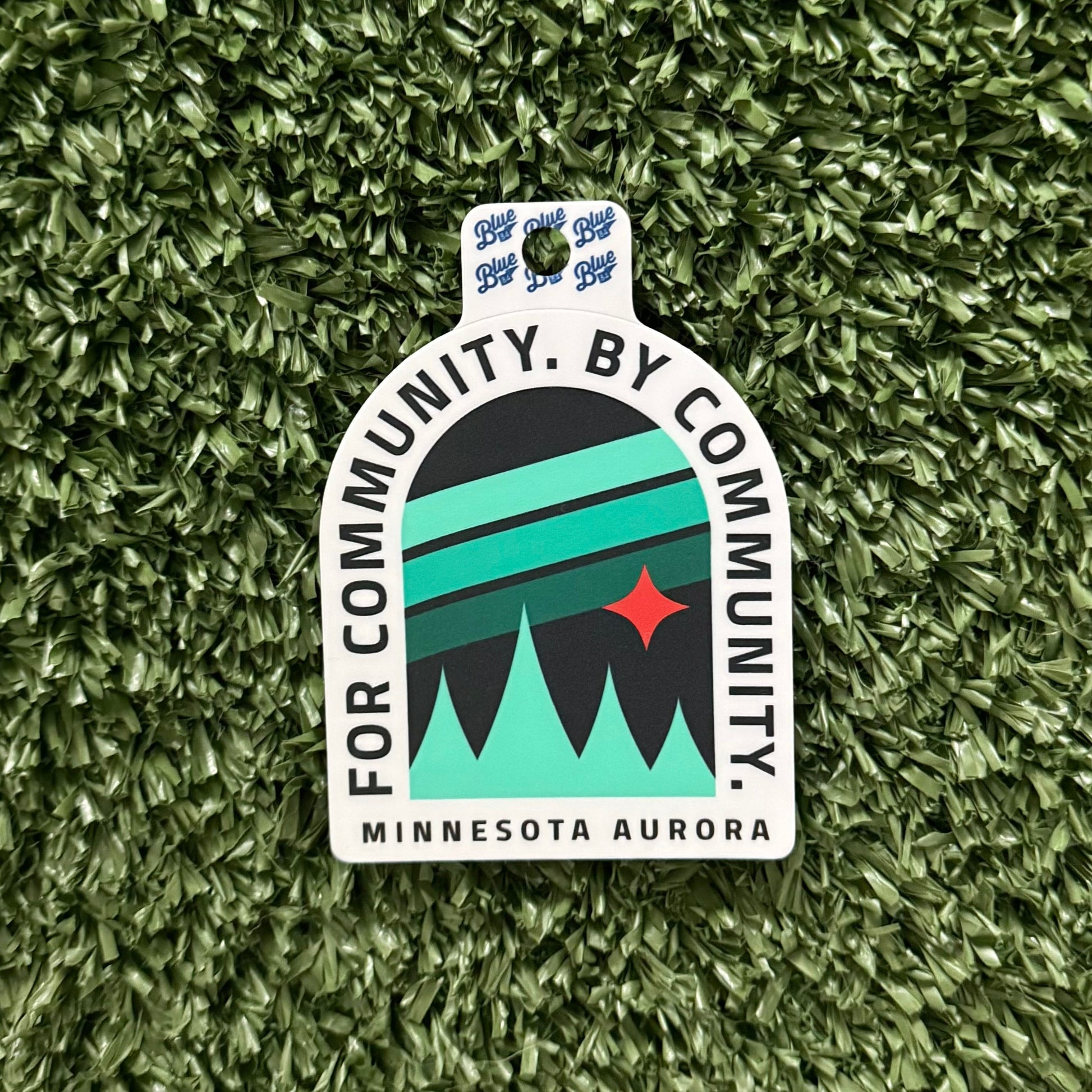 Sticker with 'For Community, By Community, Minnesota Aurora' text on a green textured background