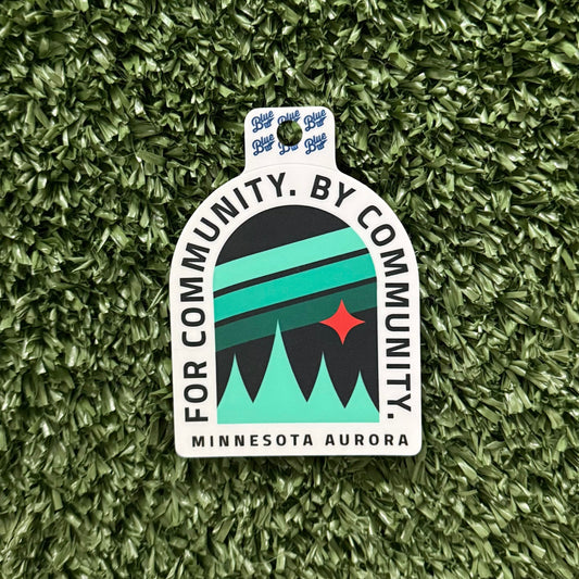 Sticker with 'For Community, By Community, Minnesota Aurora' text on a green textured background