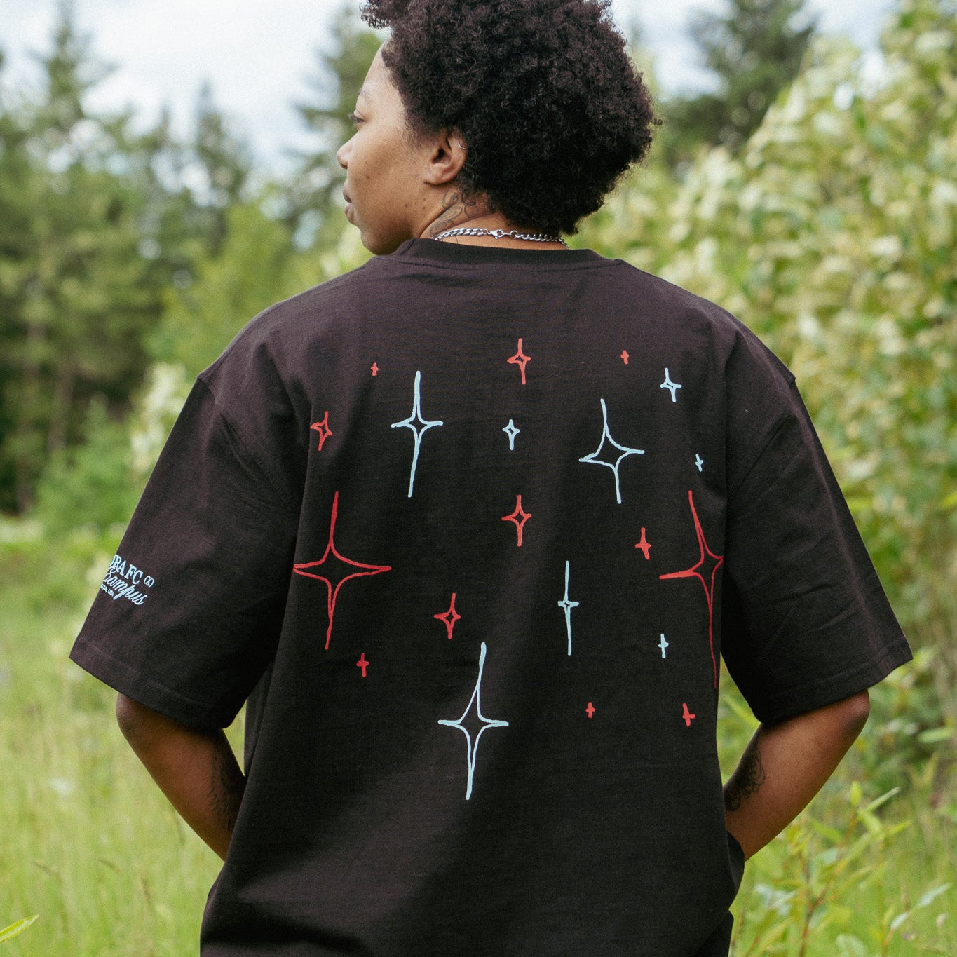 Person wearing a black t-shirt with star designs outdoors
