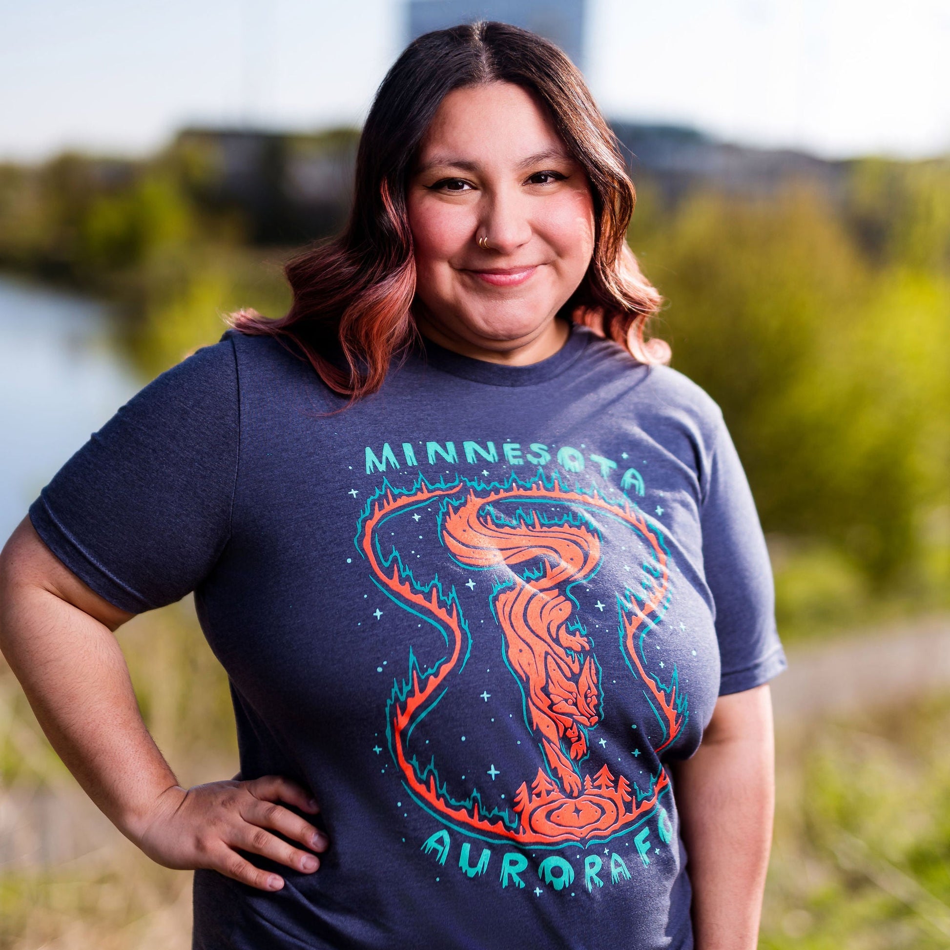 Person wearing a blue t-shirt with a graphic design outdoors
