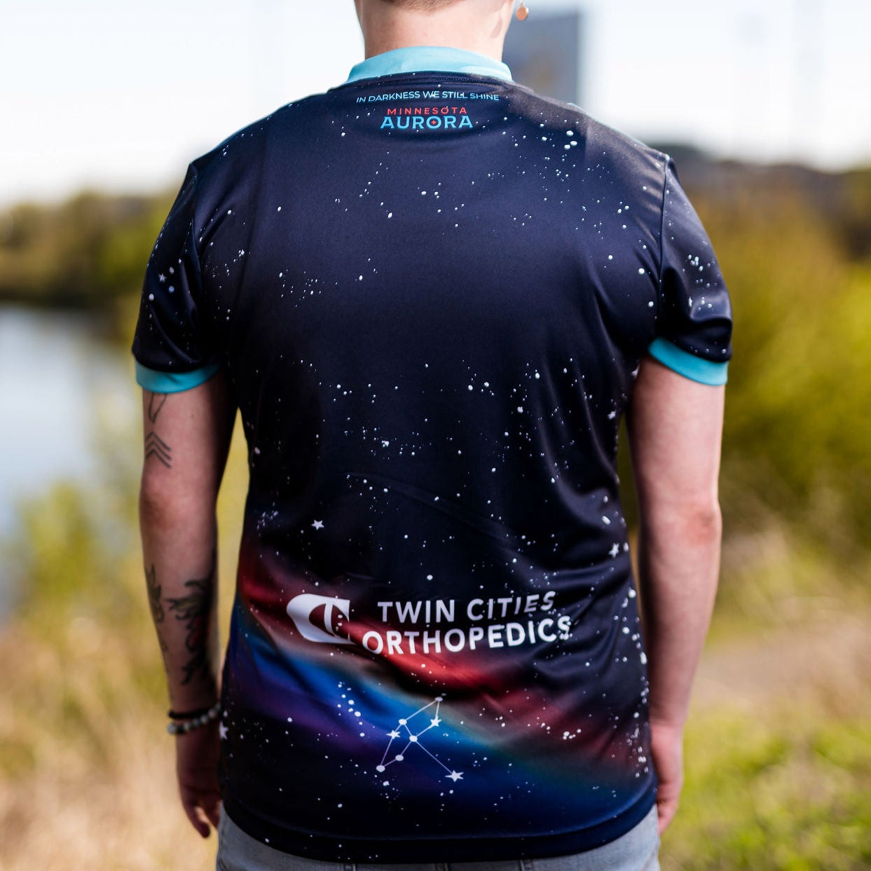 Person wearing a sports jersey with visible branding outdoors