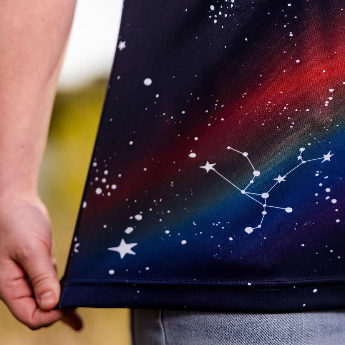 Person wearing a shirt with a starry night design featuring constellations.