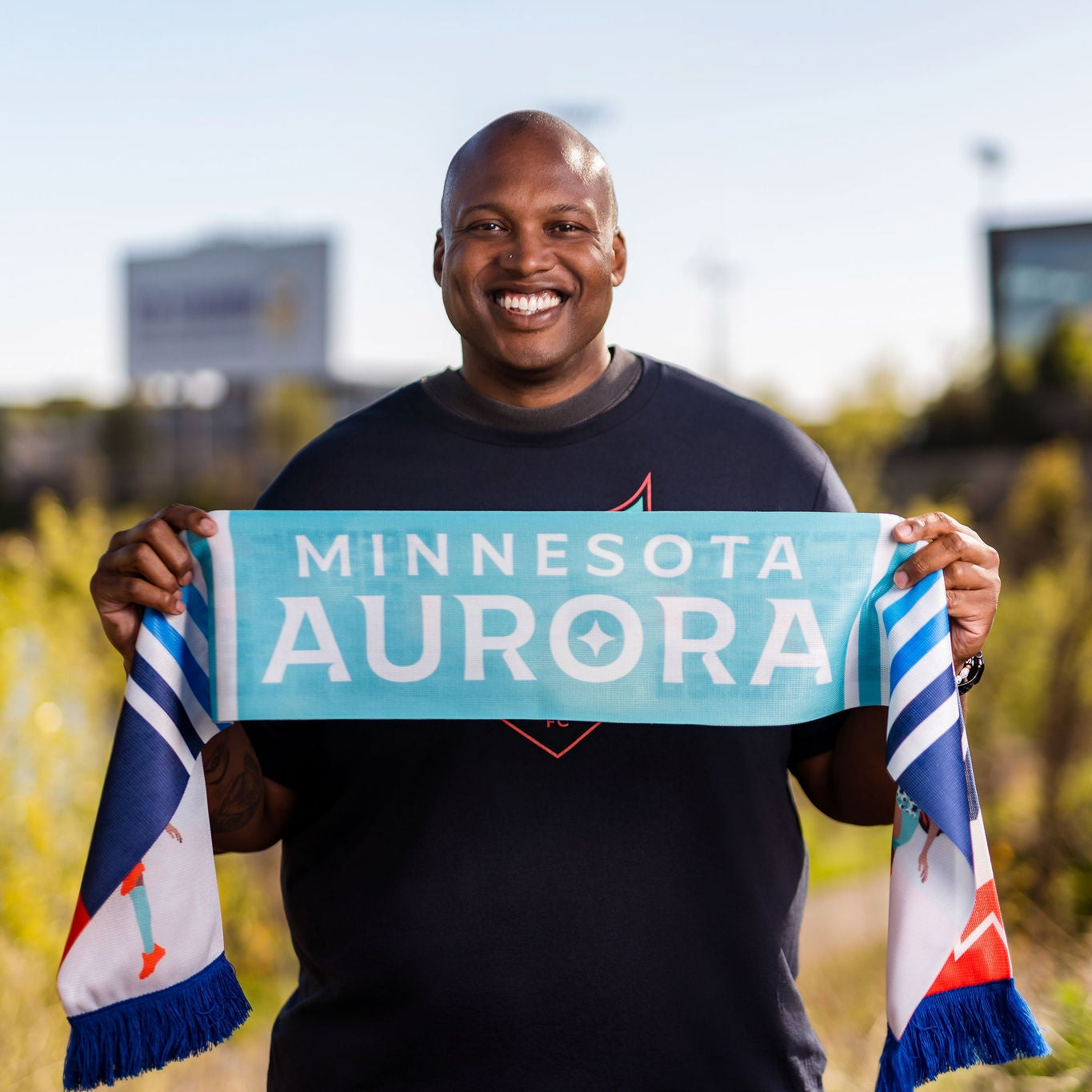 Person holding a sign with 'Minnesota Aurora' outdoors