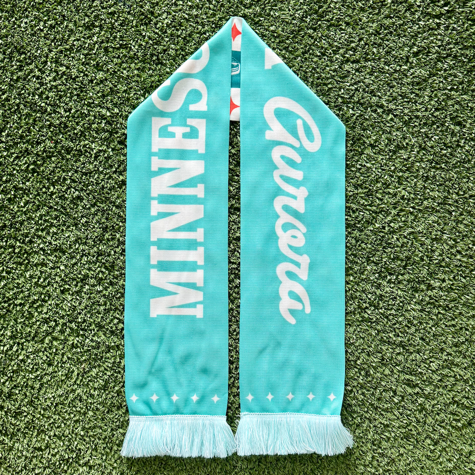 Teal scarf with white text on a green grass background